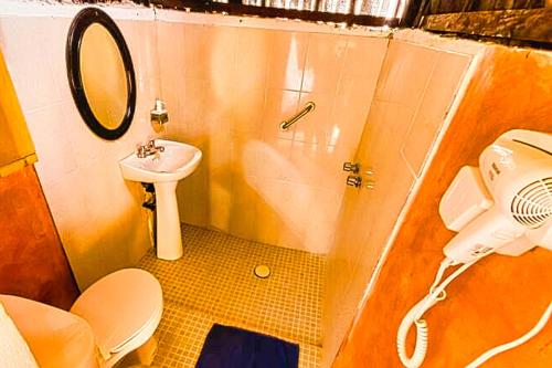een badkamer met een wastafel, een toilet en een spiegel bij Beachfront Casa Maya Lodge in El Cuyo