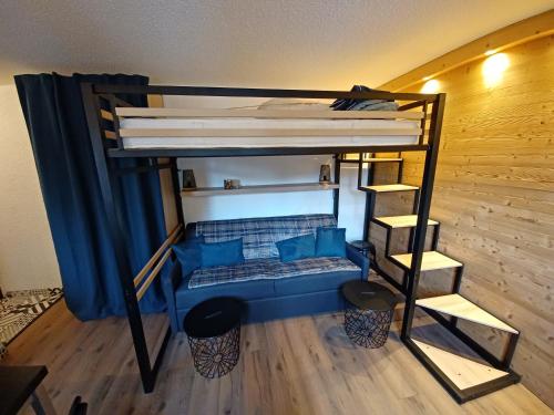 Pokój z łóżkiem piętrowym z niebieskimi poduszkami w obiekcie Studio cosy et chaleureux w mieście Valloire