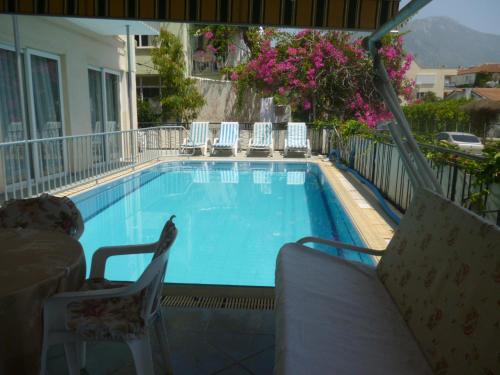 a large swimming pool with chairs at Cicek Hotel & Apartments in Fethiye