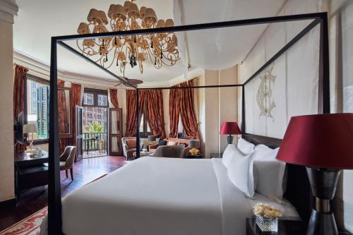 a bedroom with a large bed and a chandelier at Sofitel Legend Old Cataract in Aswan