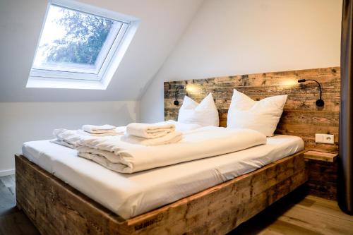 een bed met witte kussens en een raam in een kamer bij Smart Resorts Haus Opal Ferienwohnung 404 in Winterberg