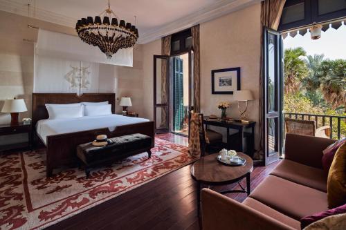 a bedroom with a bed and a living room at Sofitel Legend Old Cataract in Aswan