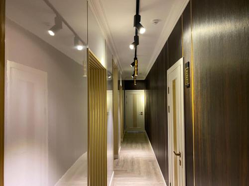 a hallway with white walls and a hallway with wooden doors at Kaspi Hotel in Uralsk