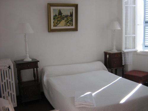 ピアナにあるMaison d'hôtes San Pedruのベッドルーム1室(白いベッド1台、ナイトスタンド2台付)