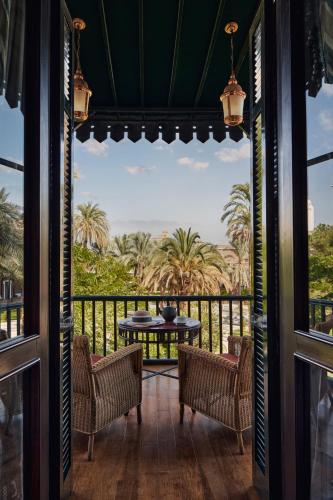 a view from the porch of a resort with a table and chairs at Sofitel Legend Old Cataract in Aswan
