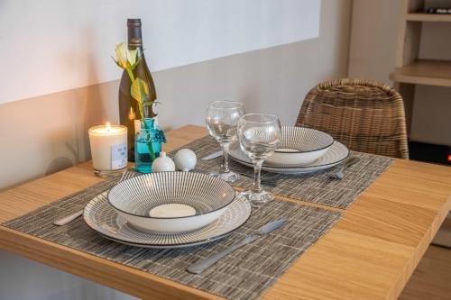 - une table avec des assiettes, des verres à vin et une bougie dans l'établissement Bel aparté, cosy, vue panoramique cathédrale, à Bourges