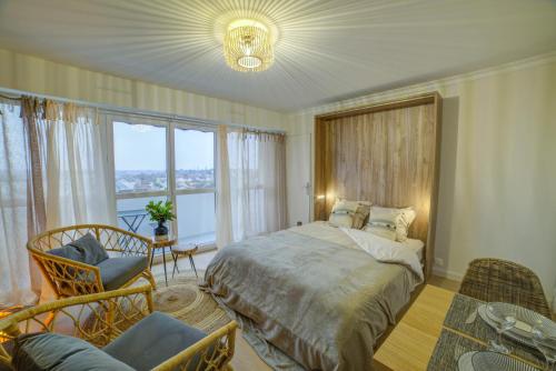 ブールジュにあるBel aparté, cosy, vue panoramique cathédraleのベッドルーム1室(ベッド1台、大きな窓付)