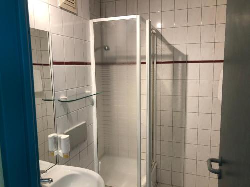 La salle de bains est pourvue d'une douche et d'un lavabo. dans l'établissement REGIOHOTEL Halle Leipzig Airport, à Schkeuditz