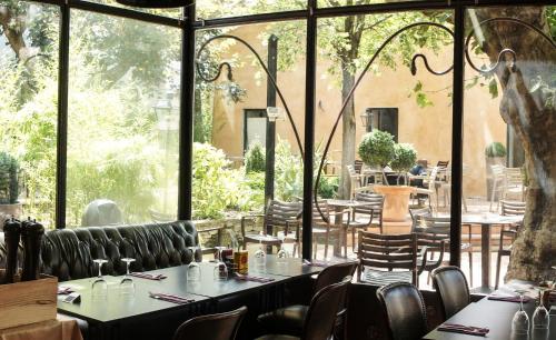 un restaurante con mesas y sillas y una gran ventana en Hotel de France en Saint-Maximin-la-Sainte-Baume