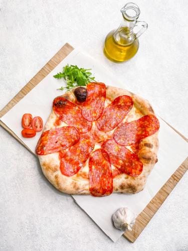 una pizza de pepperoni encima de una tabla de cortar en Hotel Czerniewski, en Varsovia