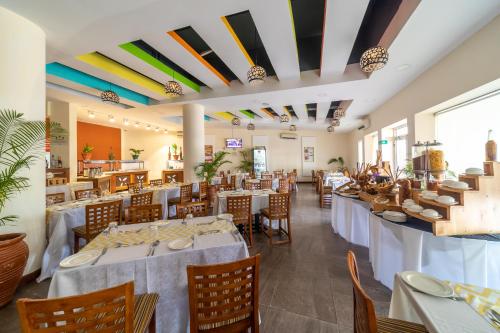 a dining room with tables and chairs in a restaurant at PrideInn Hotel Mombasa City in Mombasa