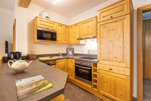 a kitchen with wooden cabinets and a counter top at Apparthaus Sonnenberg in Haus im Ennstal