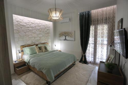 LA Larissa Luxury Apartments Peneus في لاريسا: غرفة نوم بسرير ونافذة كبيرة