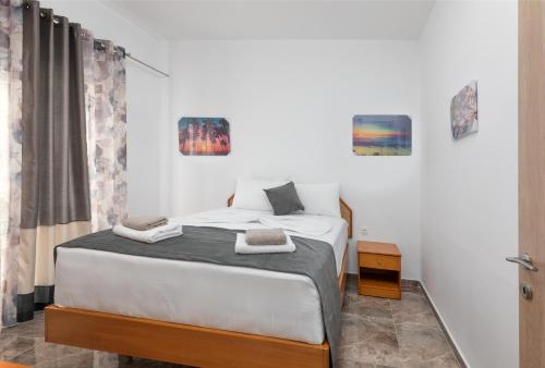 a bedroom with a bed with two towels on it at Paradise Garden in Kolimbia