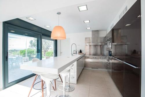 a kitchen with a white counter and a large window at Villa Forma Nou in Mahón