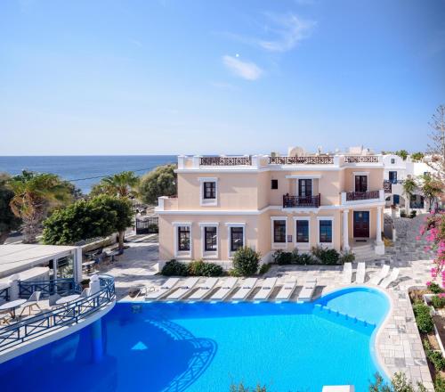 a villa with a swimming pool and the ocean at Veggera Beach Hotel in Perissa