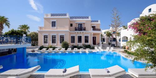 a villa with a swimming pool and lounge chairs at Veggera Beach Hotel in Perissa