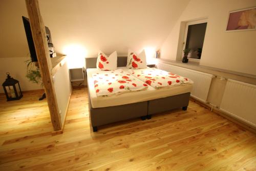 a bedroom with a bed with red flowers on it at Ferienwohnung Kurort Jonsdorf in Kurort Jonsdorf