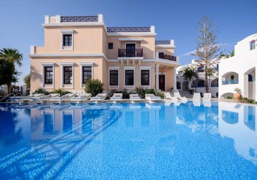 a large swimming pool in front of a building at Veggera Beach Hotel in Perissa