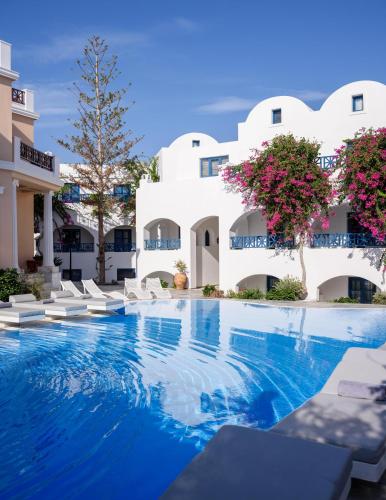 a hotel with a swimming pool and white buildings at Veggera Beach Hotel in Perissa