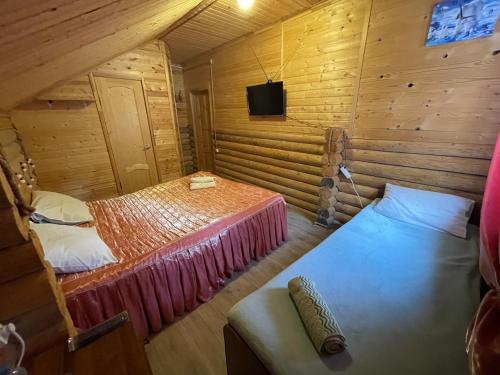 アルヒズにあるAquamarine Mini Hotelの木造キャビン内のベッド2台が備わる部屋