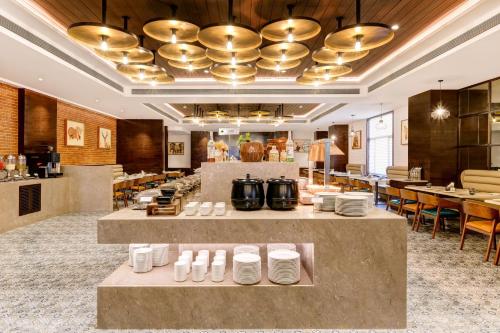 a restaurant with tables and plates on display at Lemon Tree Premier, Dwarka in Dwarka