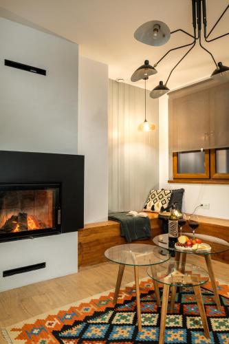 a living room with a couch and a fireplace at Tylko Tu i Teraz- Sauna, Balia z jacuzzi, Bon turystyczny in Baligród