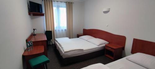 um quarto de hotel com uma cama e uma secretária e uma cama sidx sidx sidx em Motel Port 2000 em Mostki