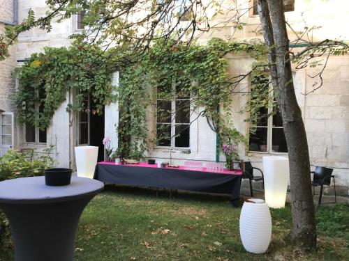 a table in the yard of a house with flowers at Vieille rose in Niort
