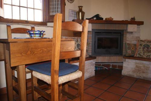 eine Küche mit einem Schreibtisch, einem Stuhl und einem Kamin in der Unterkunft casa rural Aaiun in Riópar