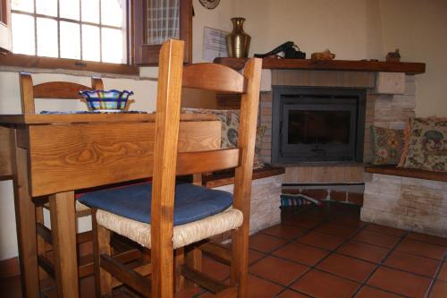 a kitchen with a desk and a chair and a fireplace at casa rural Aaiun in Riópar