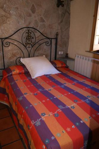 a bedroom with a bed with a colorful blanket at casa rural Aaiun in Riópar