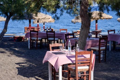 a group of tables and chairs on the beach at Veggera Beach Hotel in Perissa
