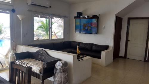 a living room with a black couch and a window at La casa del Argentino in Hawaii