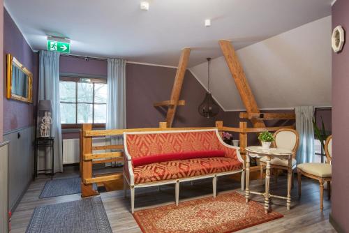 a living room with a couch and a table at Lielkalnu Muiža in Blome