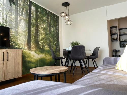 a living room with a dining room table with a forest mural at Apartmány Resort Vrchlabí in Vrchlabí