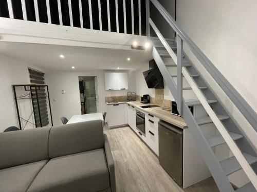 Il dispose d'une cuisine et d'un salon avec un canapé et un escalier. dans l'établissement Appartement indépendant chez l’habitant, à Puymiclan