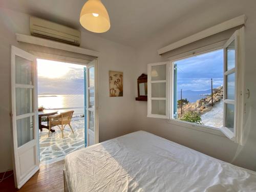 a bedroom with a bed and a view of the ocean at Anemones Sea View in Mikonos