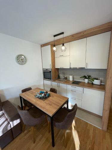 a kitchen and dining room with a wooden table and chairs at Aria Club Wellness&Spa Zlatibor in Zlatibor