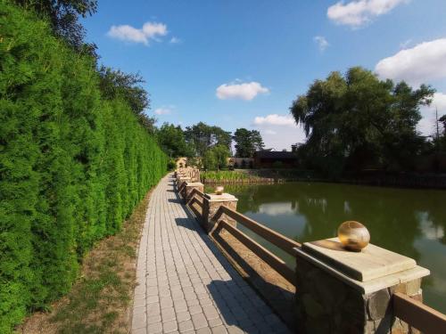 a row of park benches next to a lake at Готельно-ресторанний комплекс Прованс парк in Pochayiv