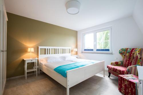 een slaapkamer met een bed, een stoel en een raam bij Seemannsgarn in Zingst