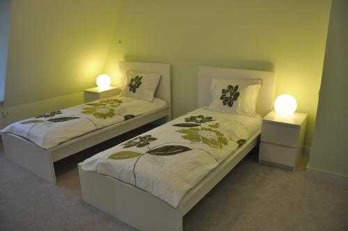 ギジツコにあるLuksusowy 100 metrowy Apartament z klimatyzacją w Giżyckuのランプ2つが付いた部屋のベッド2台