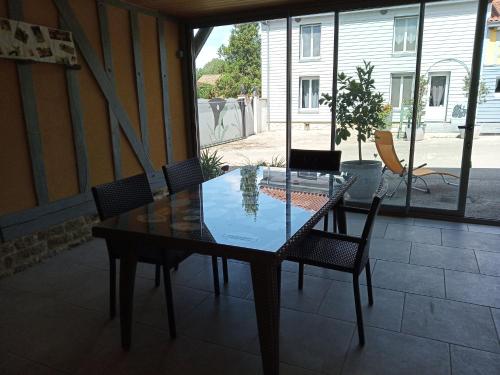 une table et des chaises en verre sur la terrasse dans l'établissement Les attelages de la fontaine, à Épothémont