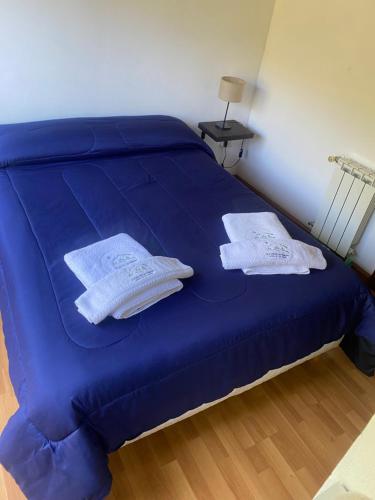 a blue bed with two pillows on top of it at Lucero de las Sierras in Sierra de los Padres