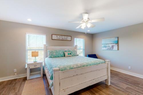 Un dormitorio con una cama y un ventilador de techo. en Island Anchors, en Gulf Shores