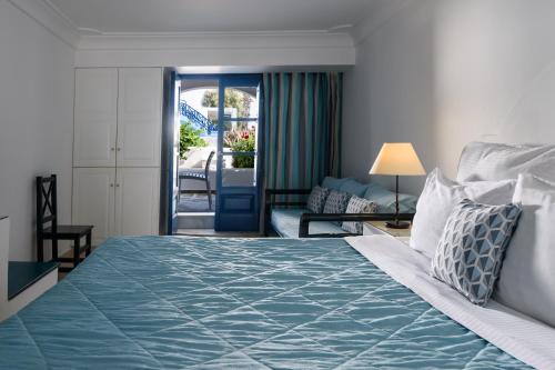 a bedroom with a bed and a living room at Veggera Beach Hotel in Perissa