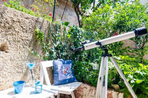 a telescope sitting next to a chair with a pillow at Apartment Caceris in Dubrovnik