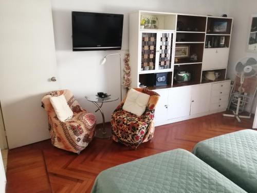 uma sala de estar com 2 cadeiras e uma televisão de ecrã plano em ESCAPADA a PdE !! em Punta del Este
