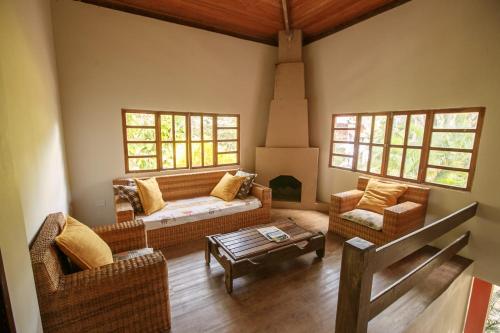 a living room with a couch and two chairs at Lendas do Capão Pousada in Vale do Capao