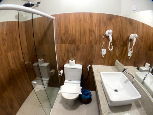 a bathroom with a toilet and a sink and a shower at Lendas do Capão Pousada in Vale do Capao